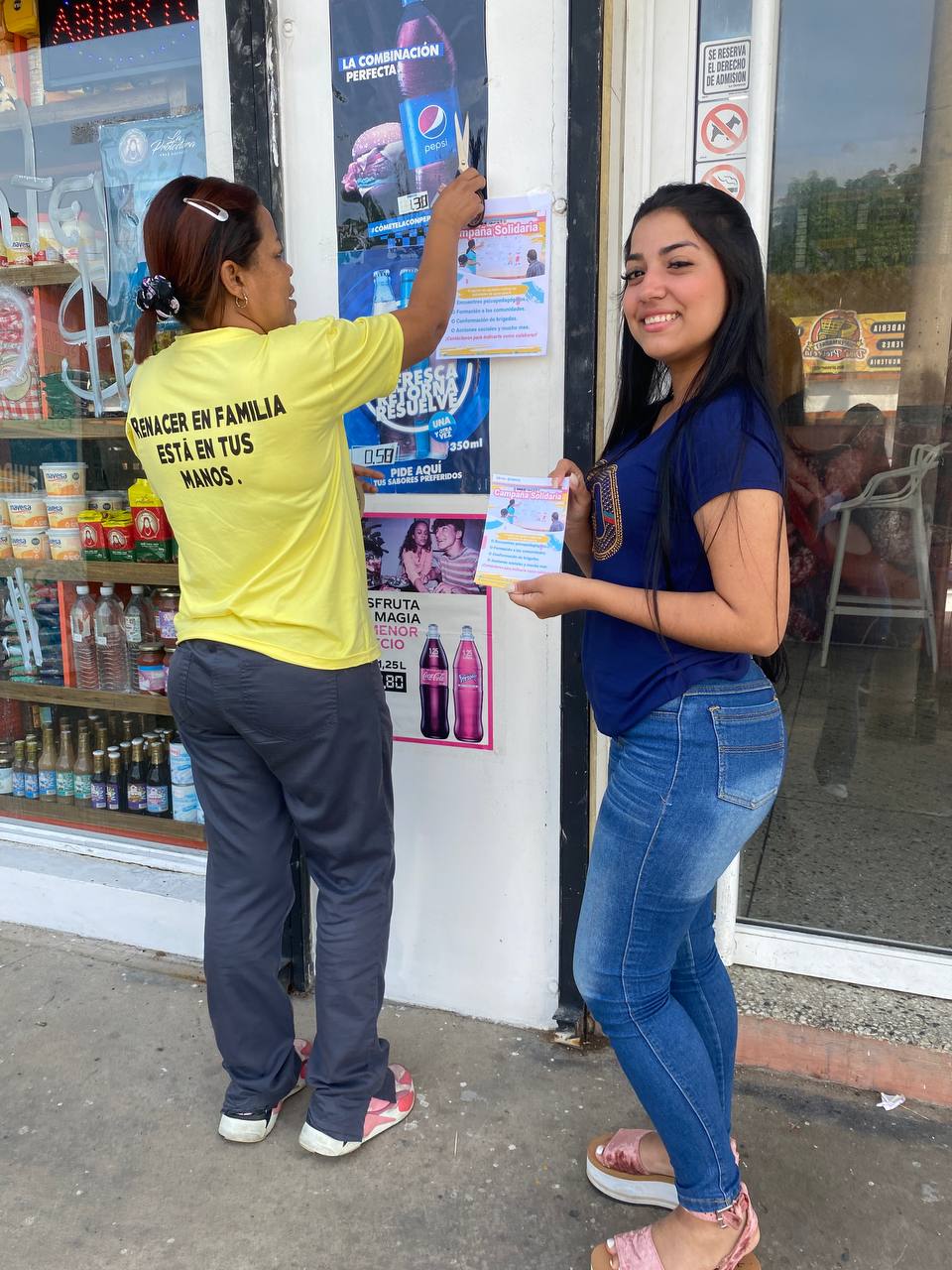 man wearing a black jacket, white shirt, blue jeans, and brown boots, playing a white electric guitar while sitting on an amp